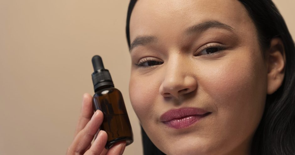 portrait-de-femme-tenant-une-bouteille-de-serum-avec-compte-gouttes
